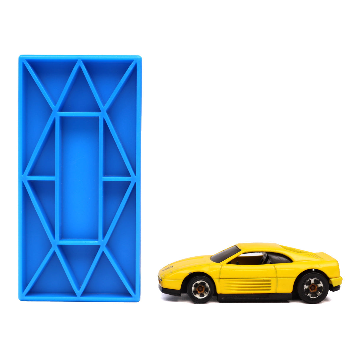 Single blue Blokix building block standing beside a yellow toy car to show the large size of the interlocking blocks from Atwood Toys