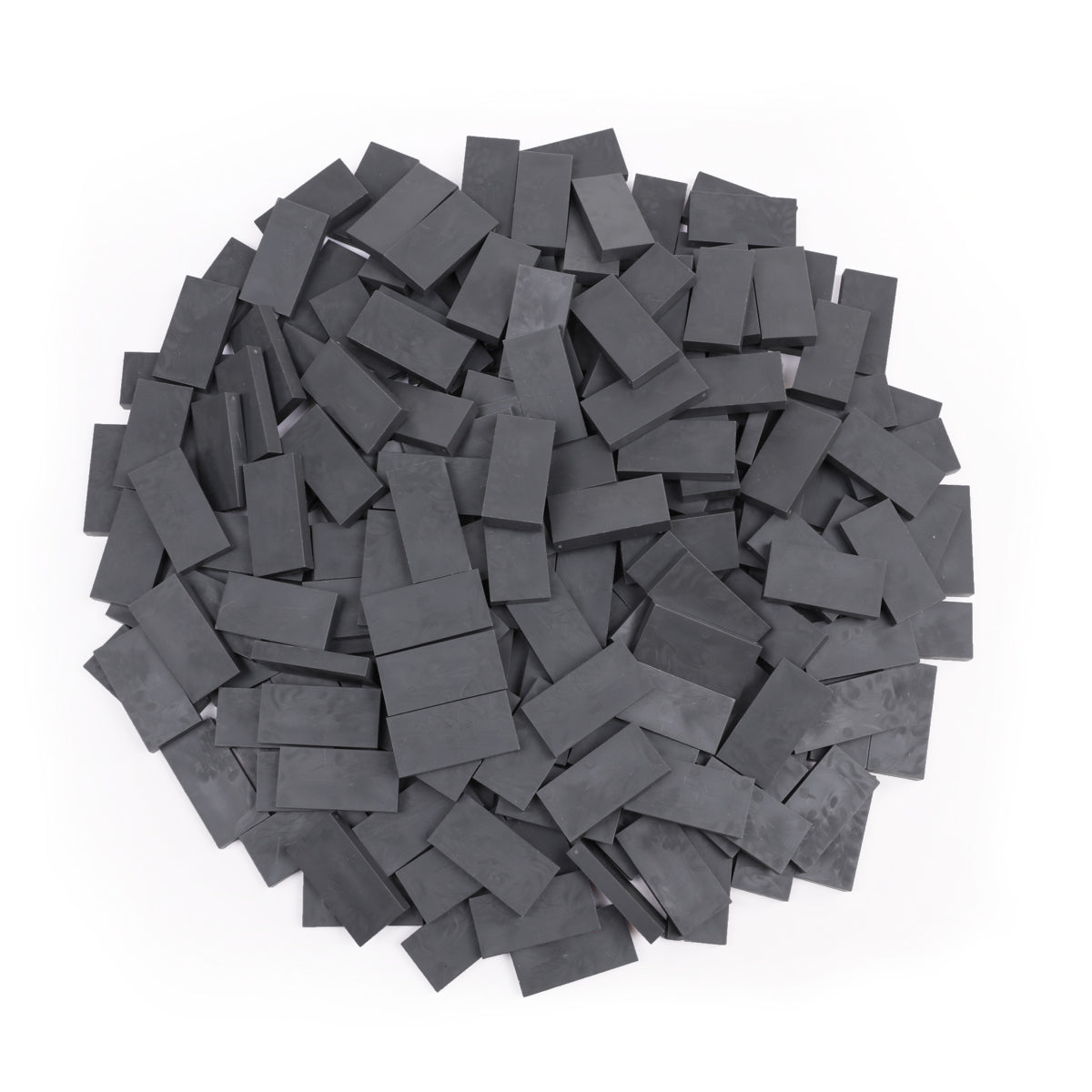 Bulk Dominoes Dark Grey Pro Dominoes from Atwood Toys, a top-down pile of solid dark grey charcoal full-weight toppling dominoes for chain reactions and domino art.
