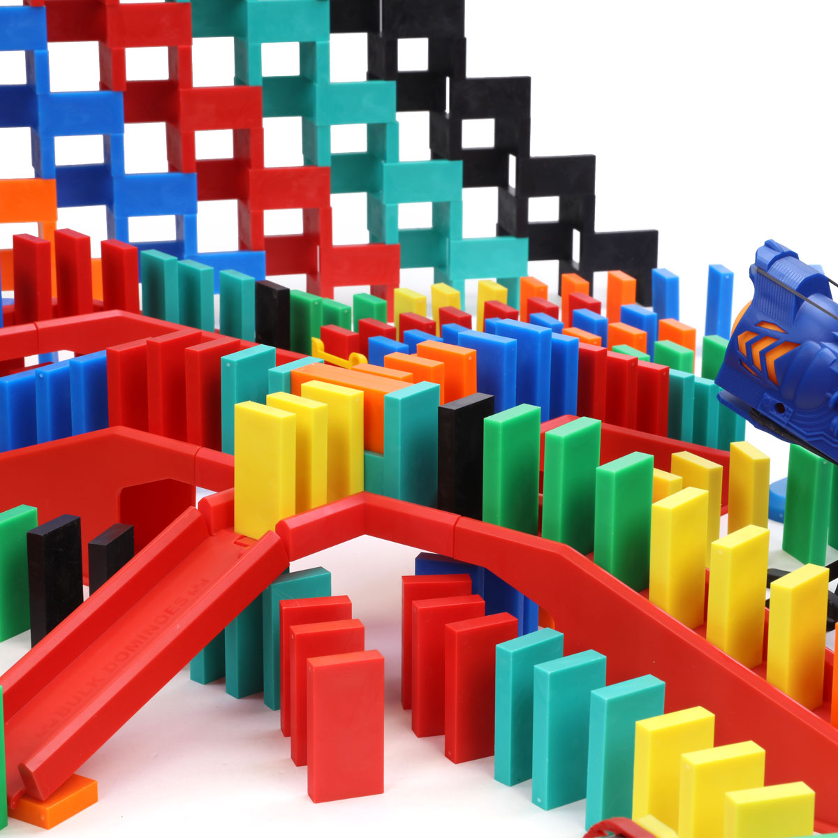 Atwood Toys Bulk Dominoes Pro Master Builder Kit checkered domino wall in red, teal, and black with multi-color Pro-Dominoes and red staircase bridges in the foreground