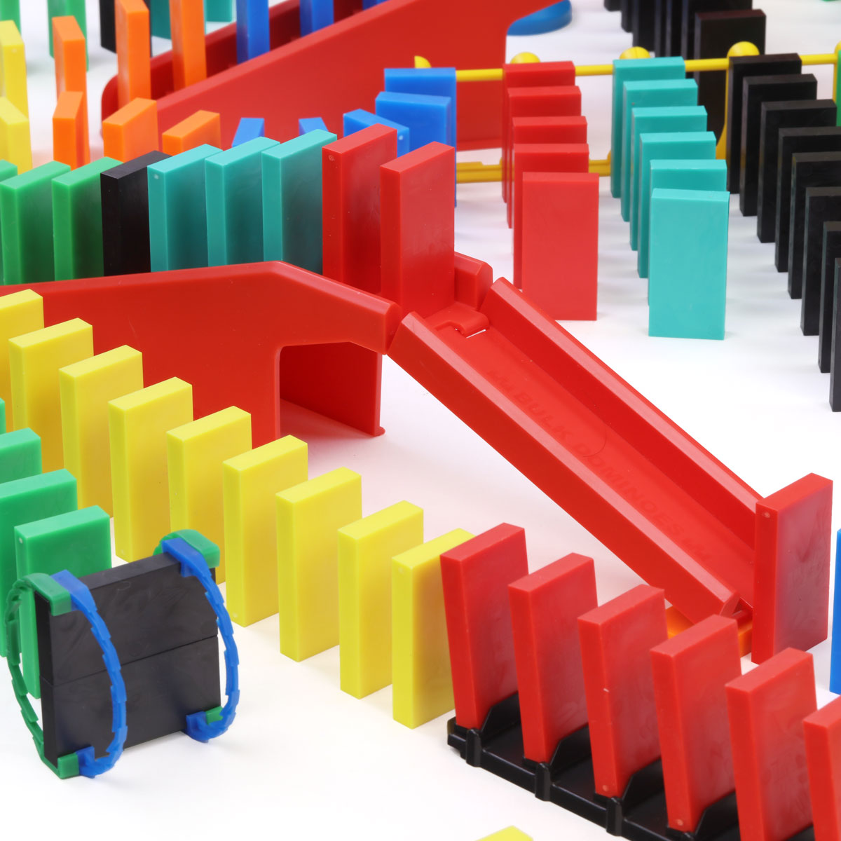 Atwood Toys Bulk Dominoes Pro Master Builder Kit close-up of red staircase bridge components with rolling Domino Arc and multi-color Pro-Dominoes lined up around it