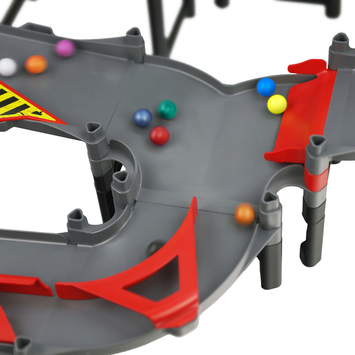 IMR Grand Prix Redline close-up of gray merger track piece with colorful marbles funneling from multiple lanes into a single path, red bumper supports and caution stripe banner visible