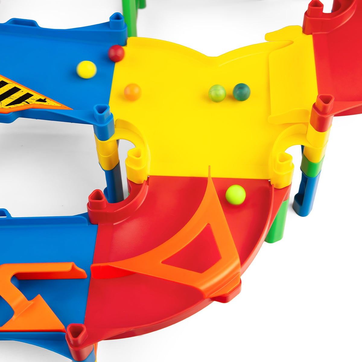 IMR Grand Prix Overdrive close-up of yellow and orange merger funnel piece with colorful marbles rolling down from blue upper lanes into merged red lower track section