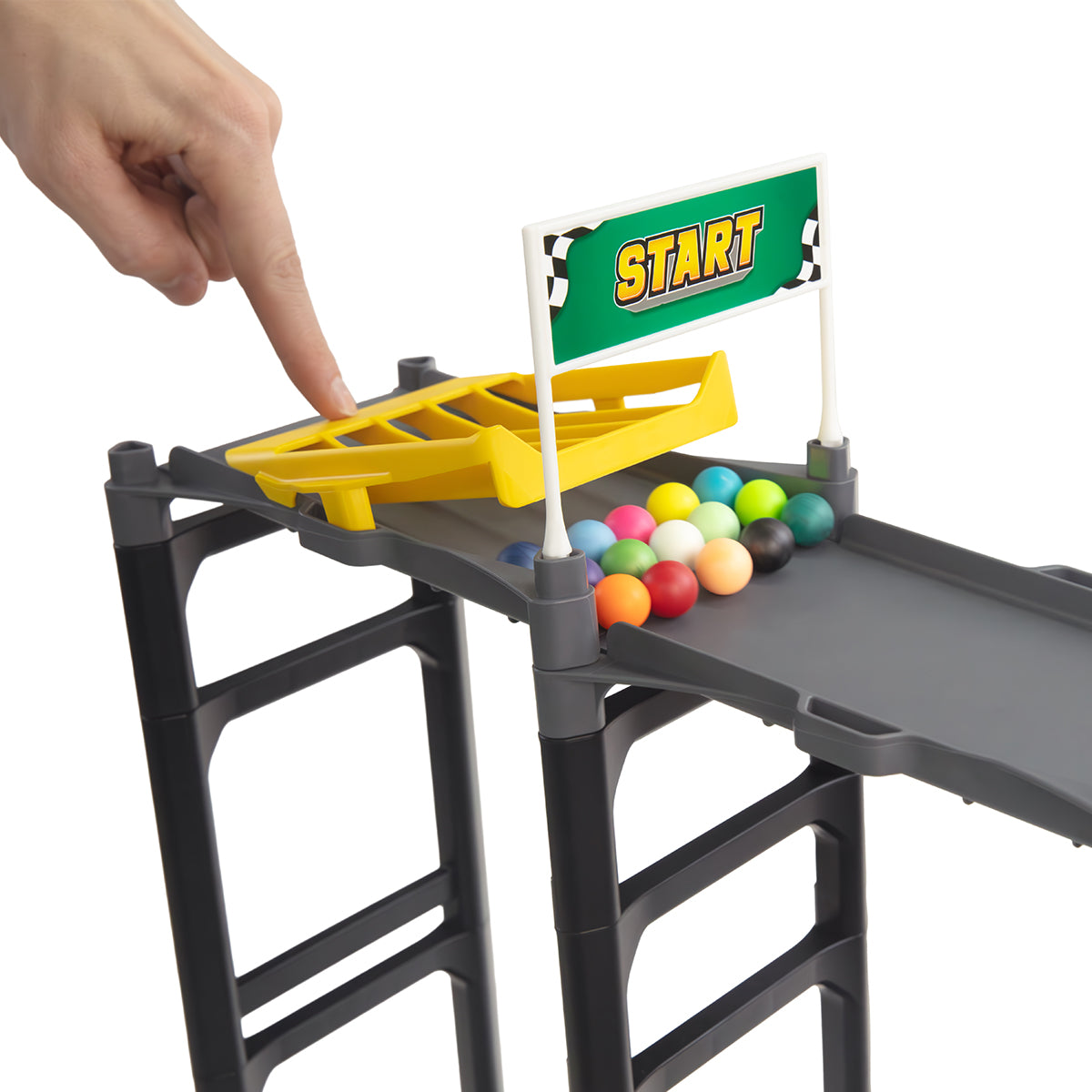 IMR Grand Prix Redline starting block close-up with hand pressing yellow marble release gate and colorful marbles loaded