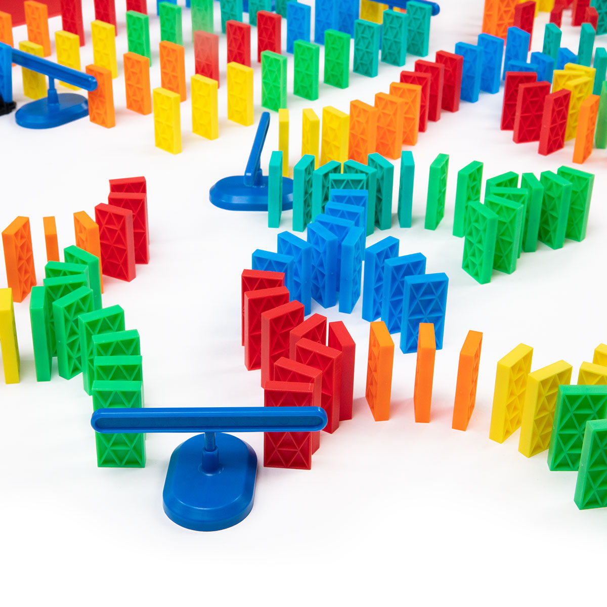 Atwood Toys Bulk Dominoes 331 Piece Kinetic Domino Toppling Kit close-up showing multi-color Pro-Scale dominoes lined up with a blue spinner accessory mid-chain reaction