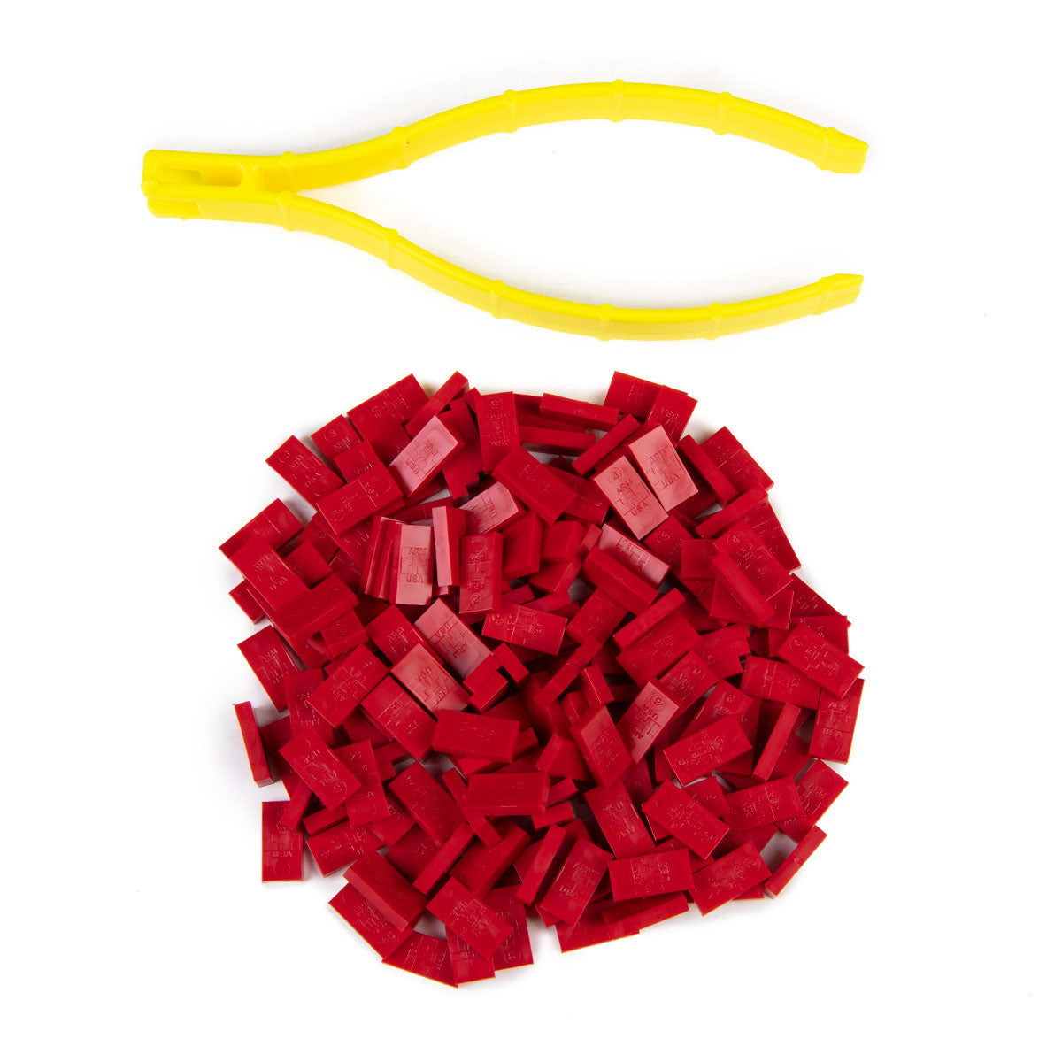 Atwood Toys World Record Mini Micro Dominoes red toppling dominoes piled together with yellow precision tweezer tool for placement and setup
