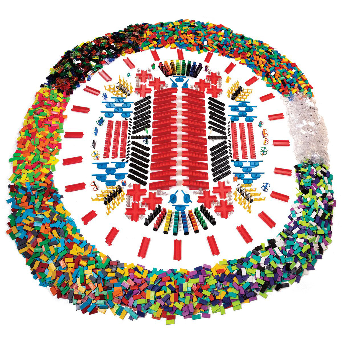 Atwood Toys Bulk Dominoes Ultra Super Galactic Kit wide shot showing 6,500+ pieces arranged in a circular display with multi-color and clear dominoes, red rapid tracks, blue spinners, and accessories