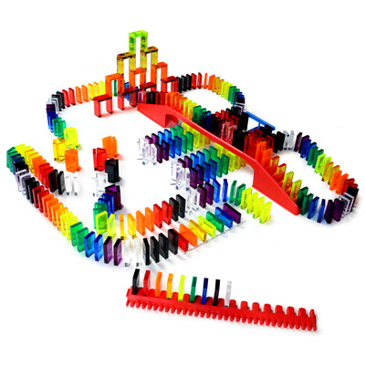 Bulk Dominoes Artisan Kit clear domino chain reaction setup with 300 translucent rainbow-colored dominoes, red bridge accessory, 3D tower structure, and straight track