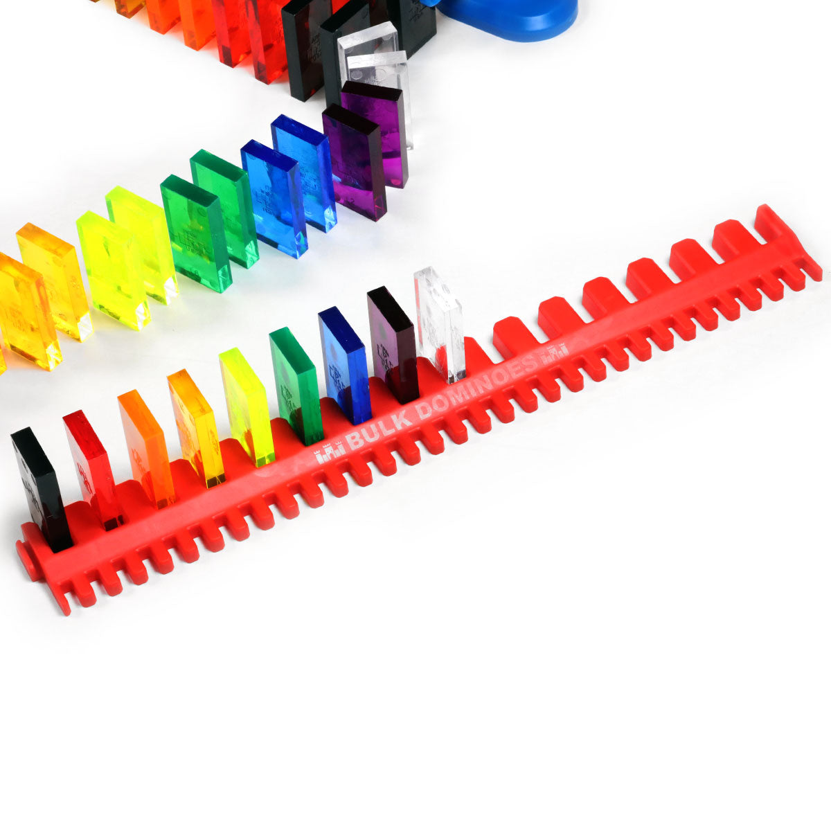 Bulk Dominoes Artisan Kit close-up of red Bulk Dominoes domino template with clear rainbow-colored dominoes loaded in slots and blue spinner accessory nearby