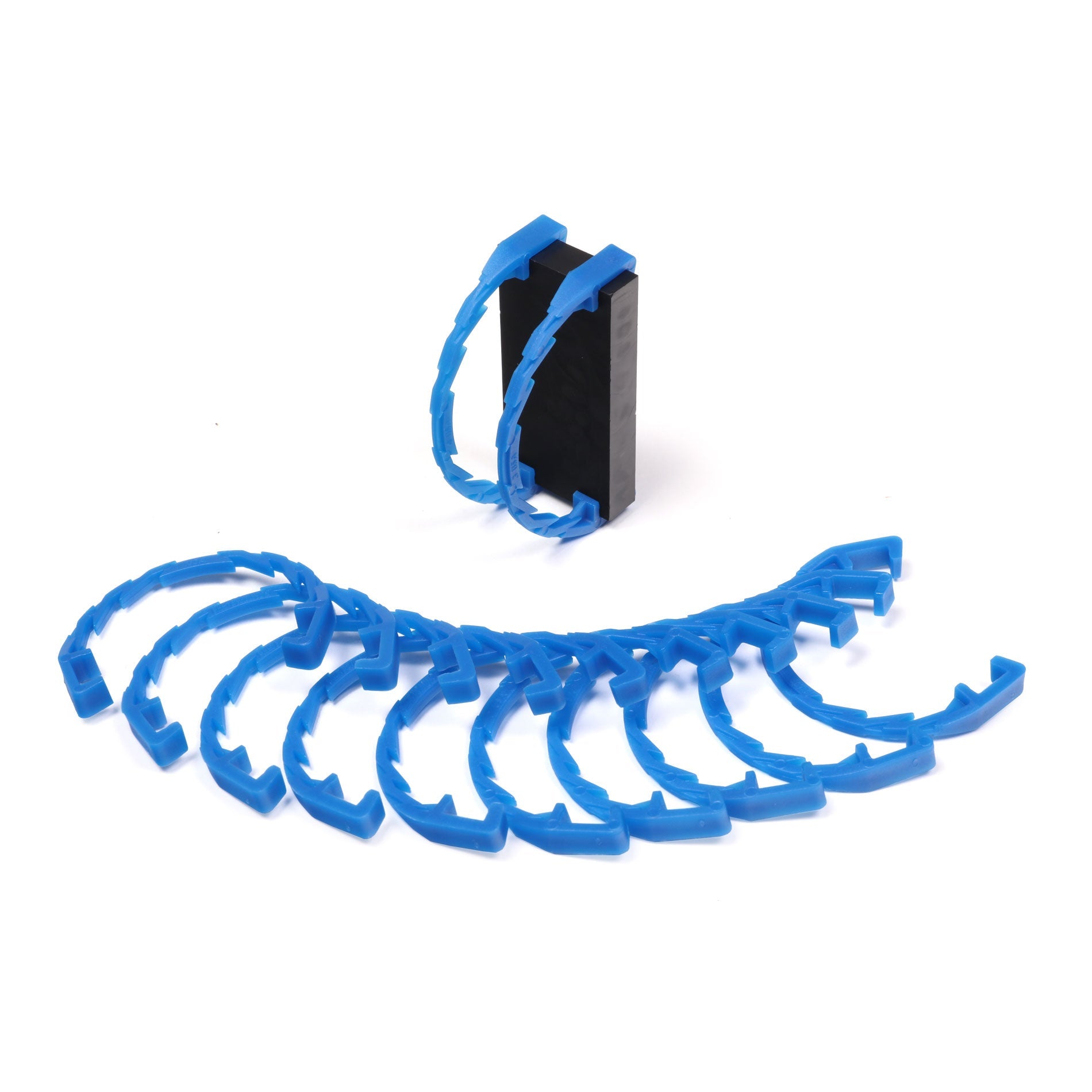 Bulk Dominoes Domino Arcs in clear transparent, 12 interlocking chain reaction clips spread in a fan with two clipped onto a black Pro Domino showing how they attach