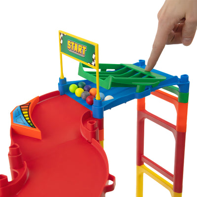 IMR Circuit Overdrive starting block close-up with hand pressing marble release gate and colorful marbles loaded