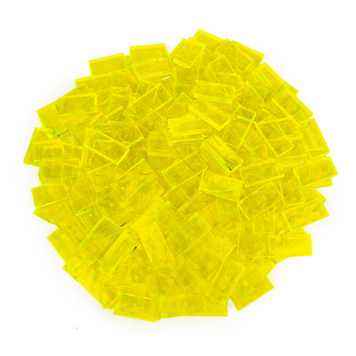 Bulk Dominoes Clear Neon Yellow Pro Dominoes from Atwood Toys, a top-down pile of translucent clear neon yellow full-weight toppling dominoes for chain reactions and domino art.