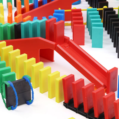 Atwood Toys Bulk Dominoes Pro Master Builder Kit close-up of red staircase bridge components with rolling Domino Arc and multi-color Pro-Dominoes lined up around it