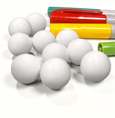 Blank white Impact Marble Racing DIY marbles beside red, yellow, green, and teal markers for coloring them in.