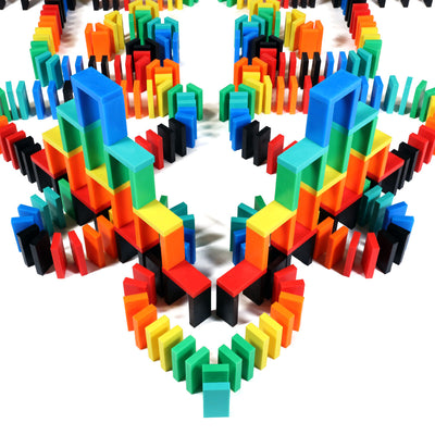 Multicolor 3D tower structure built from rainbow Bulk Dominoes Expert Kit Pro Dominoes in red, orange, yellow, green, blue, teal, and black, demonstrating advanced domino architecture.