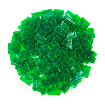 Bulk Dominoes Clear Green Emerald Pro Dominoes from Atwood Toys, a top-down pile of translucent emerald green full-weight toppling dominoes for chain reactions and domino art.