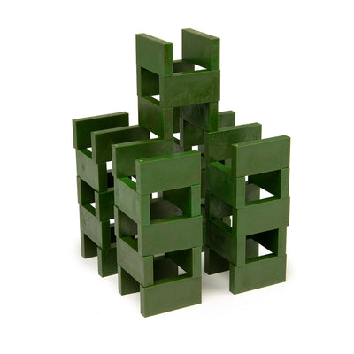 Bulk Dominoes Forest Green Pro Dominoes from Atwood Toys stacked into an open log-cabin style tower structure of interlocking green dominoes.