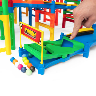 IMR Grand Prix Overdrive finish line gate with hand placing marble on green track and colorful marbles collected at the base