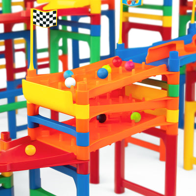 IMR Grand Prix Overdrive close-up of stacked multi-level orange impact zone peg sections with colorful marbles scattered across lanes, checkered flag on top, and bright red, blue, green, and yellow support posts