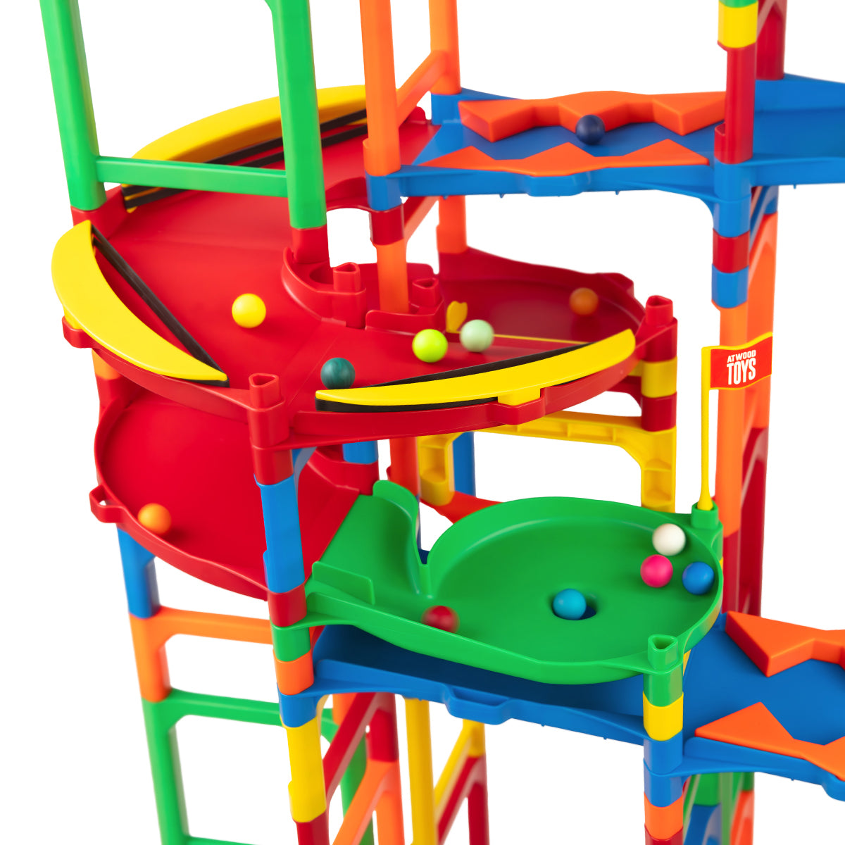 IMR Grand Prix Overdrive close-up of red spiral funnel section with colorful marbles collecting on green catch platforms below, Atwood Toys logo sticker visible, surrounded by bright multi-colored support posts