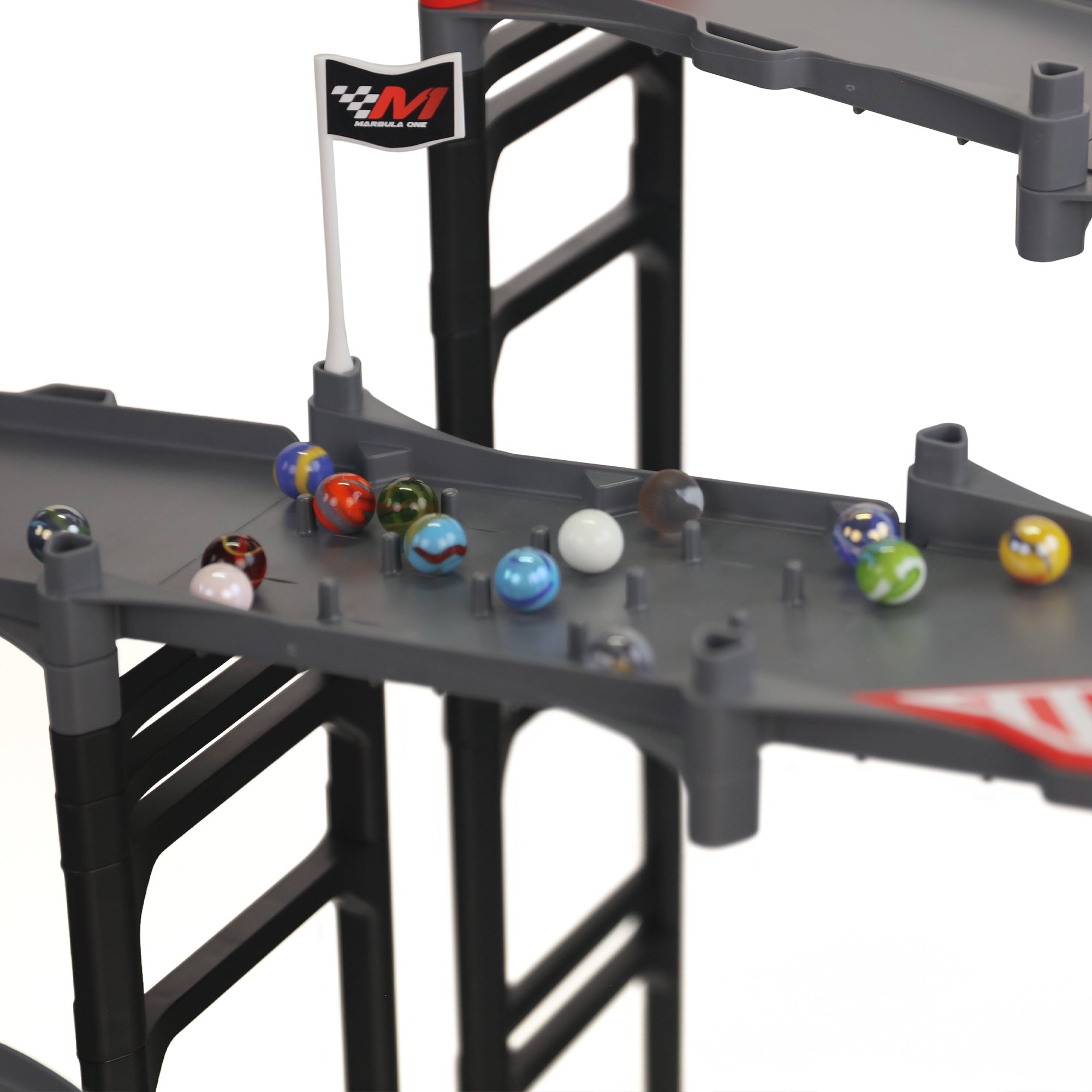 Jelle's M1 Hyper Loop close-up of impact zone peg section with official Jelle's glass marbles scattered across gray track and Marbula One flag