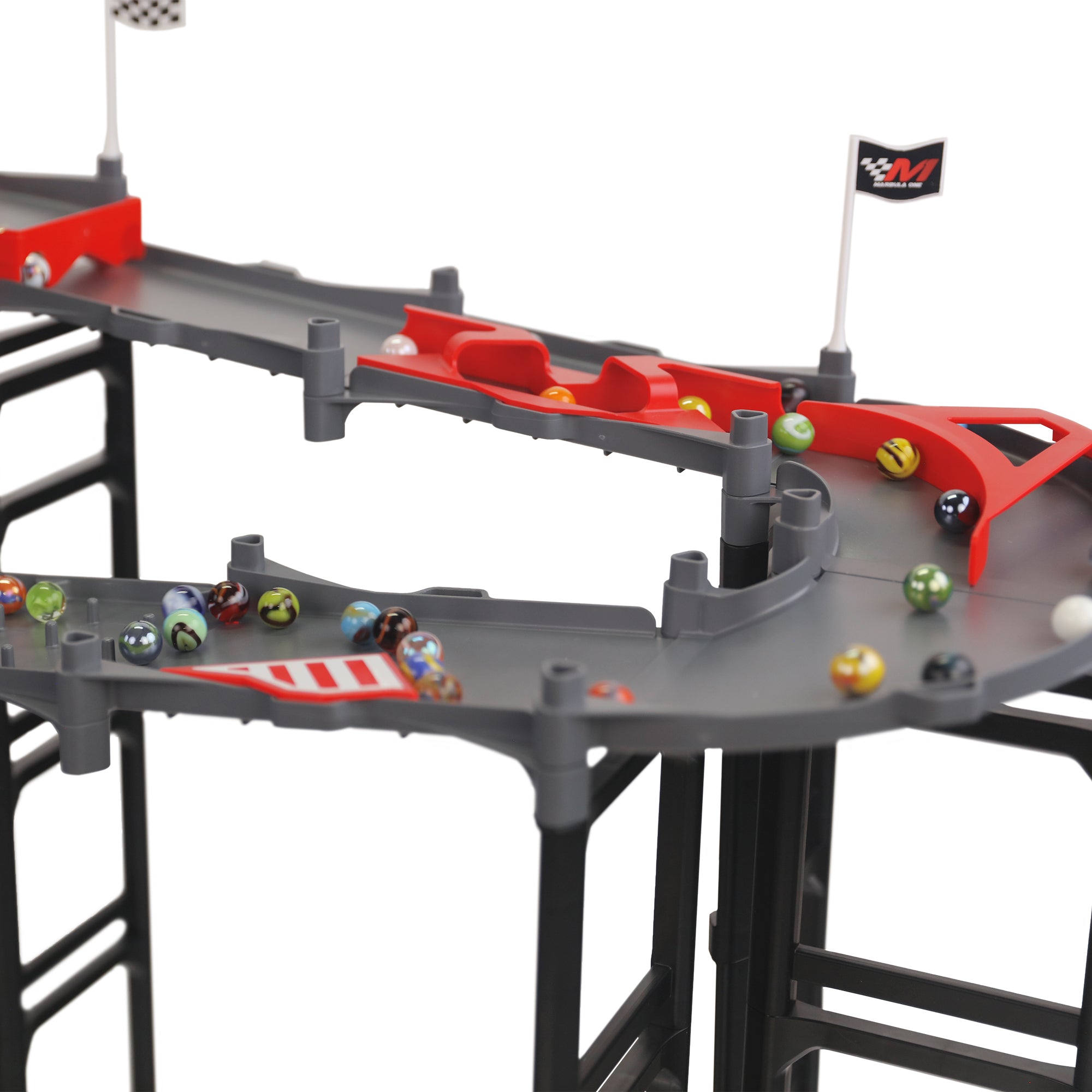Jelle's M1 Hyper Loop close-up of multi-level track with red bumper dividers, Jelle's glass marbles racing across gray lanes, checkered flag and Marbula One flag visible