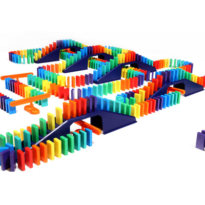 Bulk Dominoes Mini Master Kit close-up showing rainbow Mini Dominoes weaving across navy blue bridges with orange support pieces for elaborate chain reaction designs.
