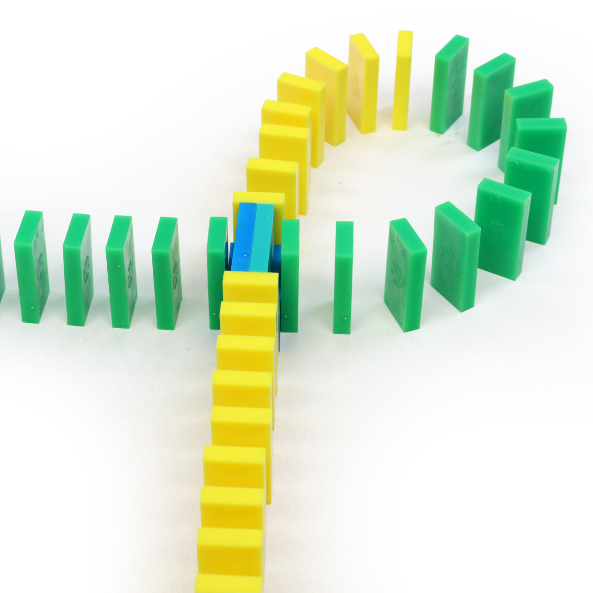 Mini Master Kit rounding-the-corner technique using yellow, green, and blue Bulk Dominoes Mini Dominoes for curved chain reactions.