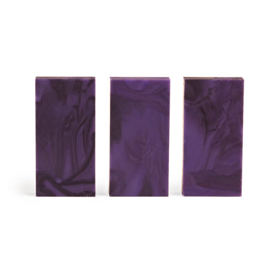 Closer view of three upright Bulk Dominoes Plasma Storm Pro Dominoes showing swirled marbling in deep purple and violet on a white background.