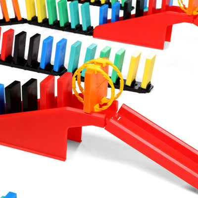 Bulk Dominoes orange Domino Arc with yellow rings rolling down a red rapid track bridge surrounded by colorful Pro Dominoes lined up on black rapid track sections