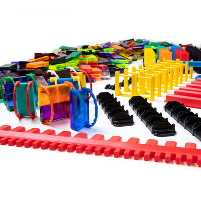 Atwood Toys Bulk Dominoes Super Mega Kit close-up of multi-color Domino Arcs, yellow line reactors, black bridges, red rapid tracks, and assorted clear dominoes
