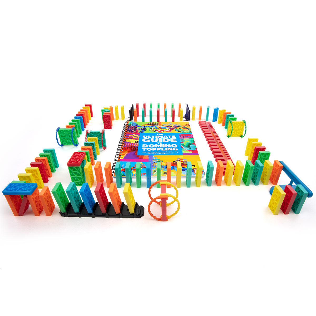 Wide angled view of the Bulk Dominoes Ultimate Starter Kit 101 from Atwood Toys featuring 100 rainbow Kinetic Dominoes, support posts, accessories, and the Ultimate Guide to Domino Toppling book.