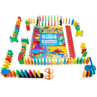 Bulk Dominoes Ultimate Starter Kit 101 from Atwood Toys with rainbow Kinetic Dominoes, red kinetic speed template, blue spinner, support posts, and the Ultimate Guide to Domino Toppling book.
